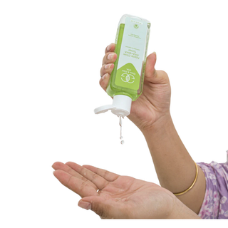 Hand holding a green bottle with pump dispenser on a white background