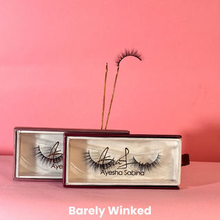 Eyelash packaging with 'Barely Winked' text on a pink background