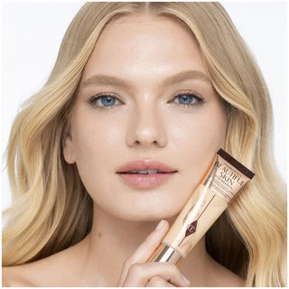 Woman holding a cosmetic tube with a neutral background
