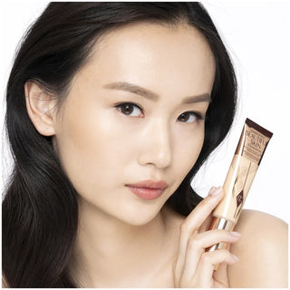 Woman holding a skincare product with a white background