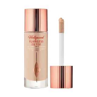Foundation bottle with applicator and rose gold cap on white background