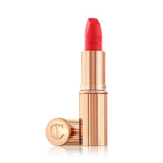 Red lipstick with rose gold casing on a white background