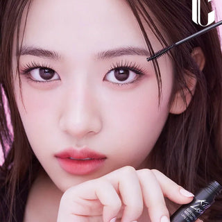 Close-up of a person applying mascara with a brush
