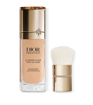 Dior Prestige foundation bottle with brush on a white background