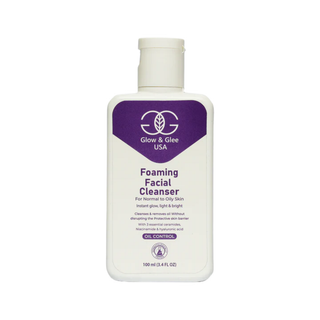Foaming facial cleanser bottle with purple label on a white background