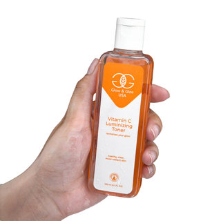 Hand holding a bottle of Glow & Glow Vitamin C Luminizing Toner on a white background