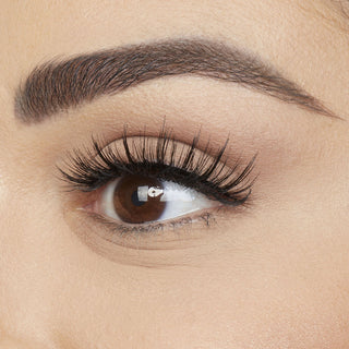 Close-up of an eye with long, dark eyelashes and a well-groomed eyebrow.