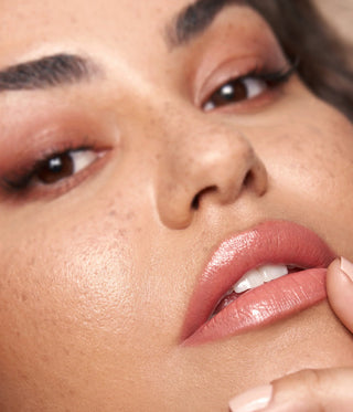 Close-up of a woman's face with a focus on her lips and skin texture.