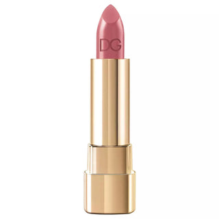 Lipstick with gold casing and pink shade on a white background