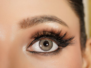 Close-up of a woman's eye with makeup, including eyelashes and eyeliner.