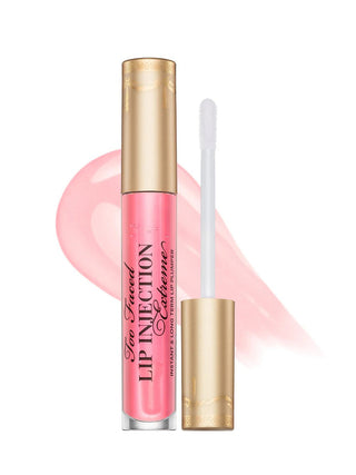 Pink lip gloss with gold cap and applicator on a white background