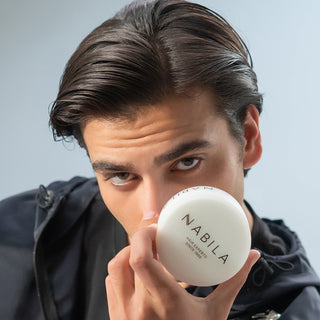 Man holding a white round product with 'Nabila' branding against a light gray background