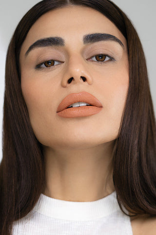 Close-up of a person with a neutral expression on a plain background